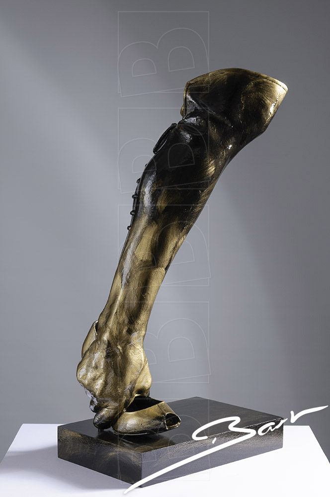 Sculpture of a boot made out of a high heeled shoe, a lady's leg and a hand