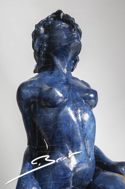 Betaalbare sculptuur van vrouw op een hertenhoef in blauw en goudkleurig bladmetaal.