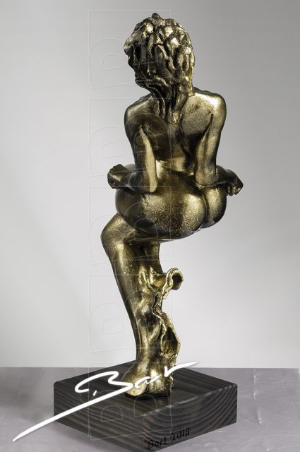 Betaalbare sculptuur van vrouw op een hertenhoef in zwart en goud.