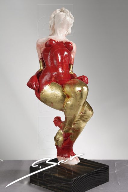 Betaalbare sculptuur van vrouw op een hertenhoef in rood, wit en goudkleurig bladmetaal.