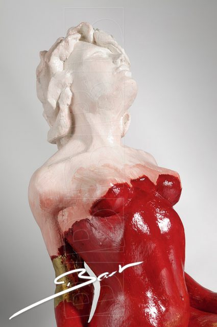 Betaalbare sculptuur van vrouw op een hertenhoef in rood, wit en goudkleurig bladmetaal.