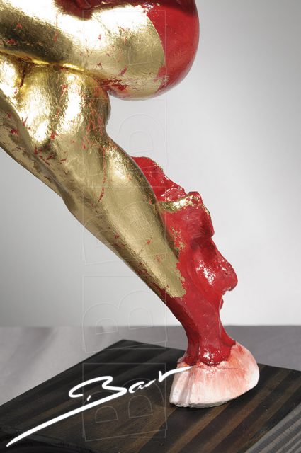 Betaalbare sculptuur van vrouw op een hertenhoef in rood, wit en goudkleurig bladmetaal.