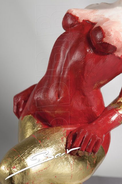 Betaalbare sculptuur van vrouw op een hertenhoef in rood, wit en goudkleurig bladmetaal.