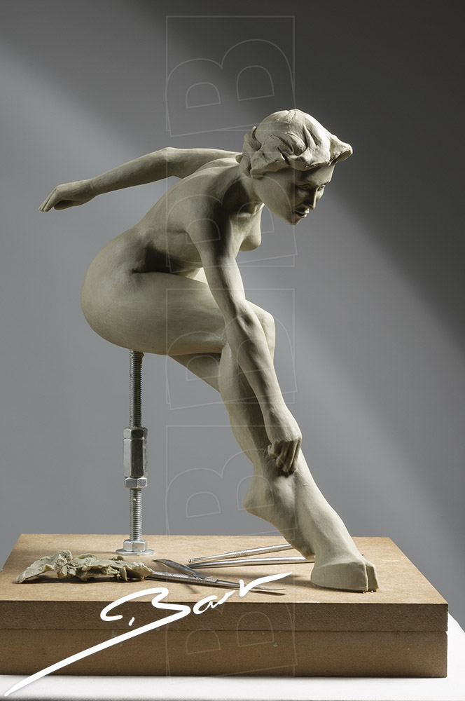 Wassculptuur van springende, naakte vrouwfiguur, een van haar voeten is een hoef. Wax sculpture of a jumping nude woman, one of her feet is a hoof.