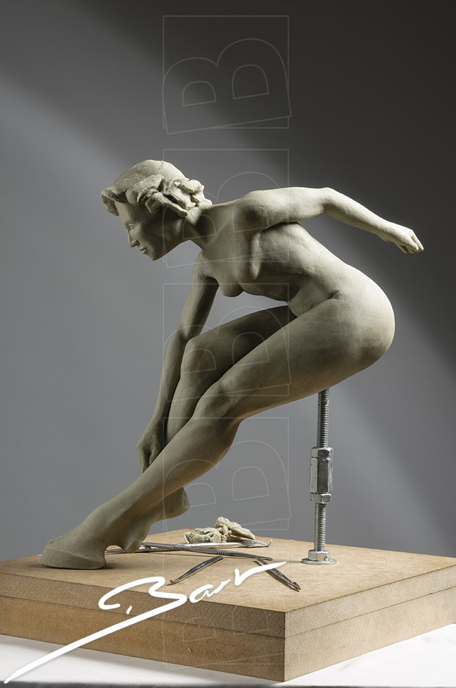 Wassculptuur van springende, naakte vrouwfiguur, een van haar voeten is een hoef. Wax sculpture of a jumping nude woman, one of her feet is a hoof.