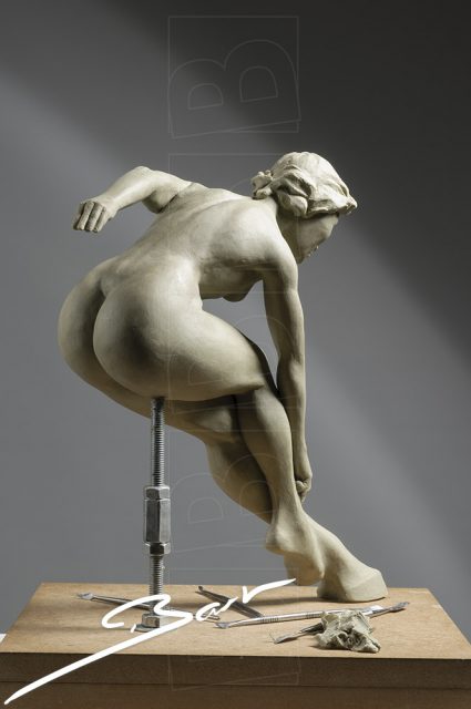 Wassculptuur van springende, naakte vrouwfiguur, een van haar voeten is een hoef. Wax sculpture of a jumping nude woman, one of her feet is a hoof.