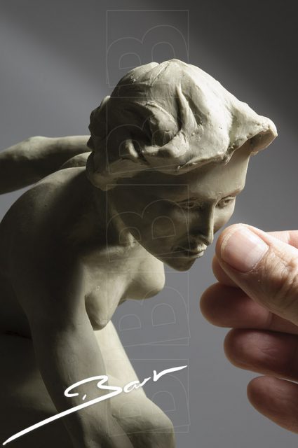 Wassculptuur van springende, naakte vrouwfiguur, een van haar voeten is een hoef. Wax sculpture of a jumping nude woman, one of her feet is a hoof.