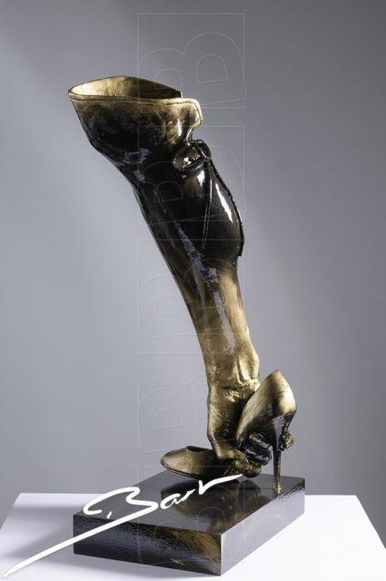 Sculpture of a boot made out of a high heeled shoe, a lady's leg and a hand