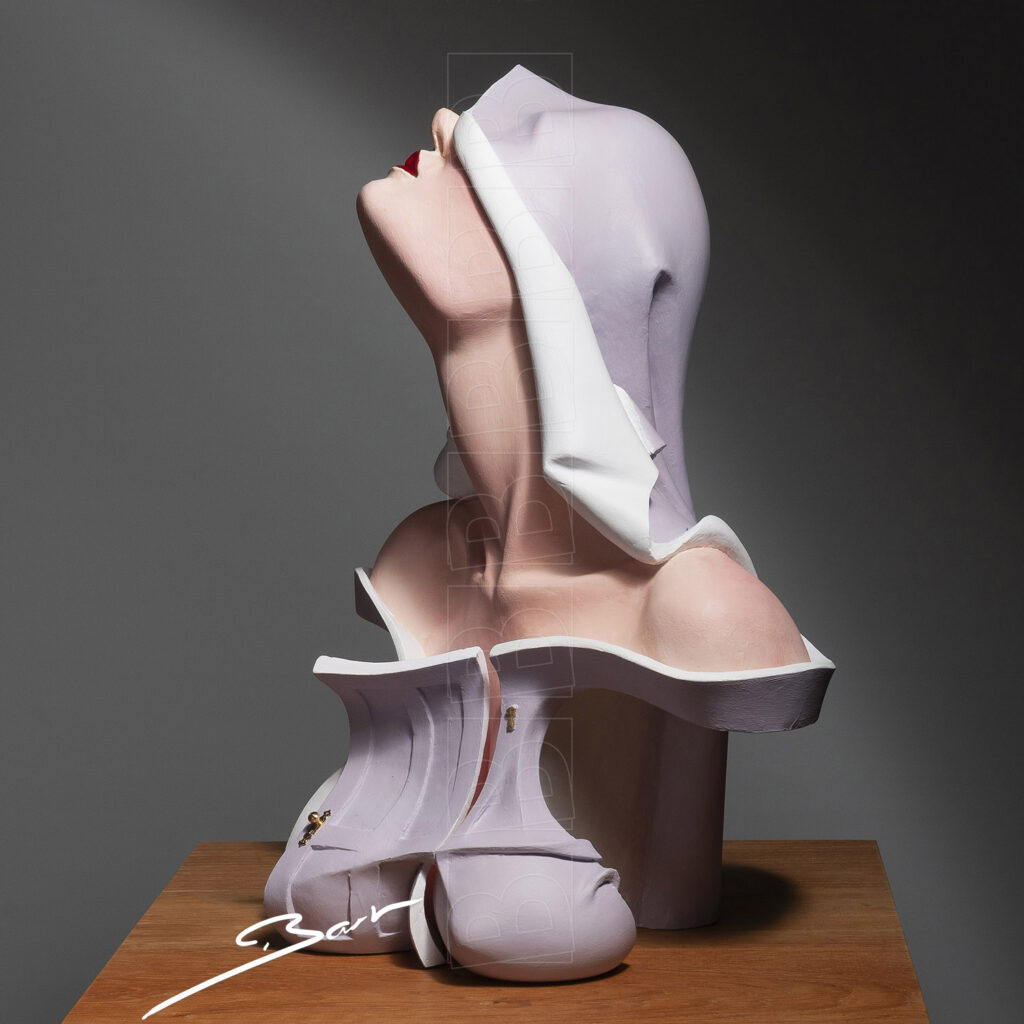 Sculptuur van hoofd en buste van een vrouw met deur voor haar boezem, geblindeerd door haar hoofddoek. Sculpture of the head and shoulders of a woman with a door before her bosom and blindfolded by her headscarf.